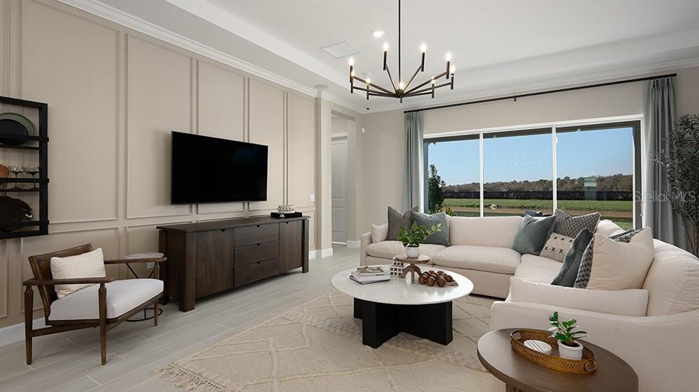 A living room features a paneled wall, a sectional sofa, and a large sliding glass door — 26752 DOVE DRIVE, PUNTA GORDA, FL