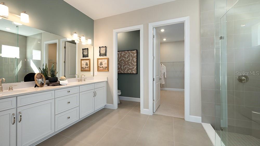 A bathroom features a double vanity, a glass-enclosed shower, and two doorways leading to other rooms — 26752 DOVE DRIVE, PUNTA GORDA, FL
