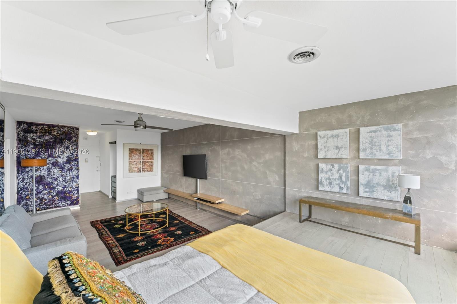 A bedroom features a gray accent wall, a yellow bed, and a dark patterned rug — 3 Island Ave, Miami Beach FL 33139, MIAMI BEACH, FL