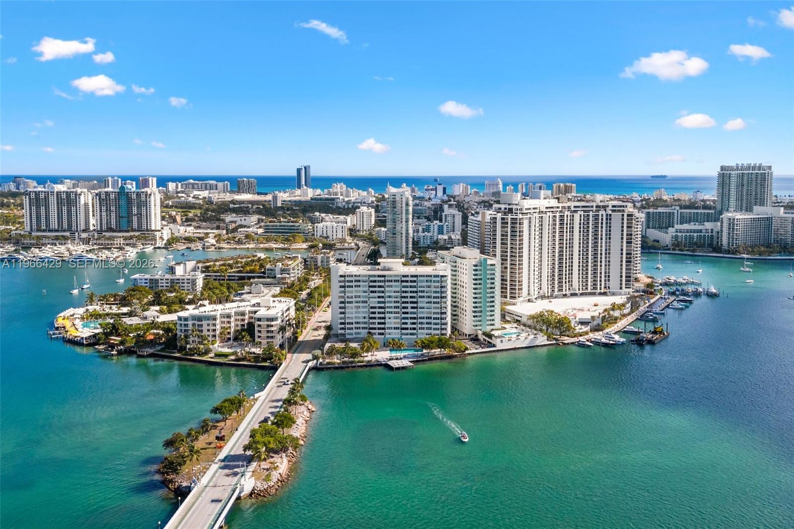 An aerial view shows a coastal city with high-rise buildings, a bridge, and boats — 3 Island Ave, Miami Beach FL 33139, MIAMI BEACH, FL