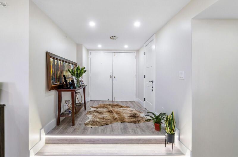 An entryway features a raised floor with LED lighting, a cowhide rug, and a console table — 1900 Consulate Place # 406, West Palm Beach FL 33401, WEST PALM BEACH, FL