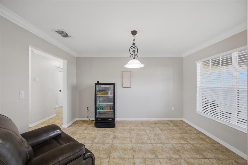A dining area with tile flooring, a glass-front beverage cooler, and a hanging light fixture — 14185 DORADO STREET, SPRING HILL, FL
