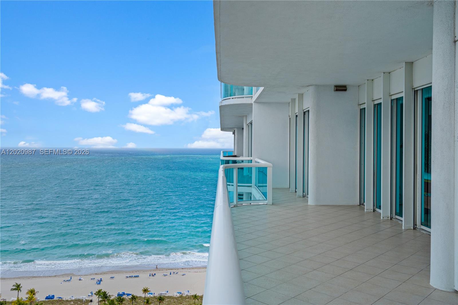 A high-rise balcony features tiled flooring, glass railings, and an expansive ocean view — 10101 Collins Ave, Bal Harbour FL 33154, BAL HARBOUR, FL