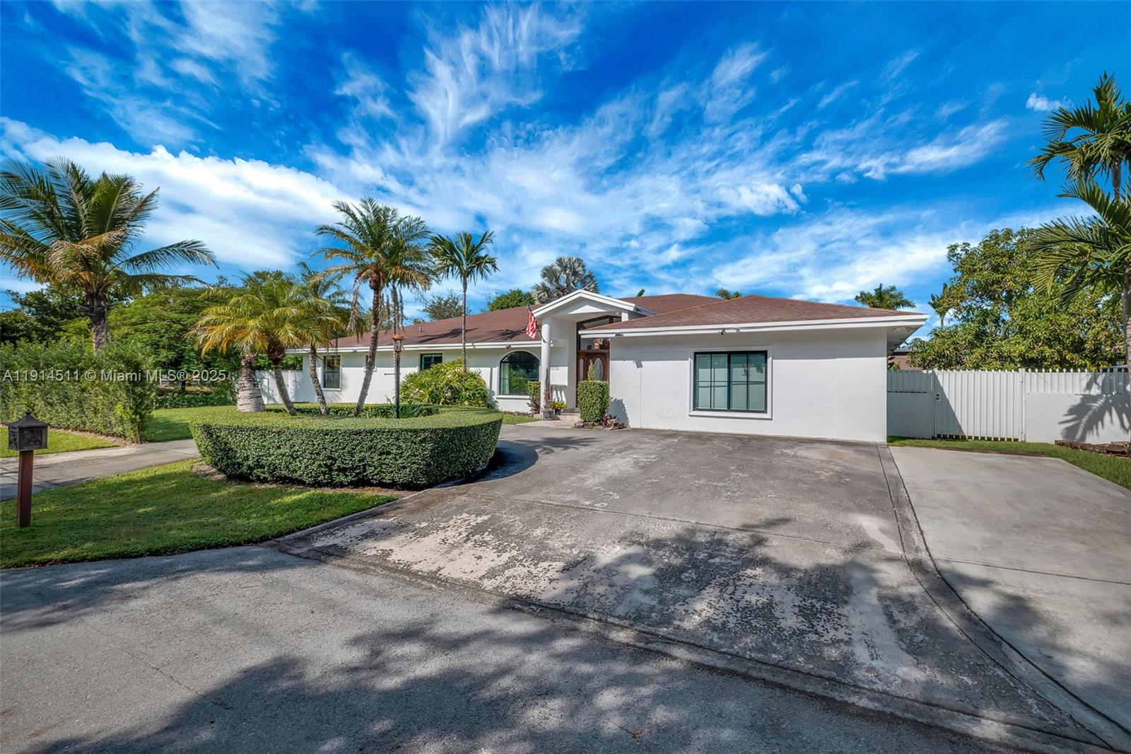A single-story white house with a concrete driveway, palm trees, and a manicured hedge — 10195 NW 26th St, Doral FL 33172, DORAL, FL