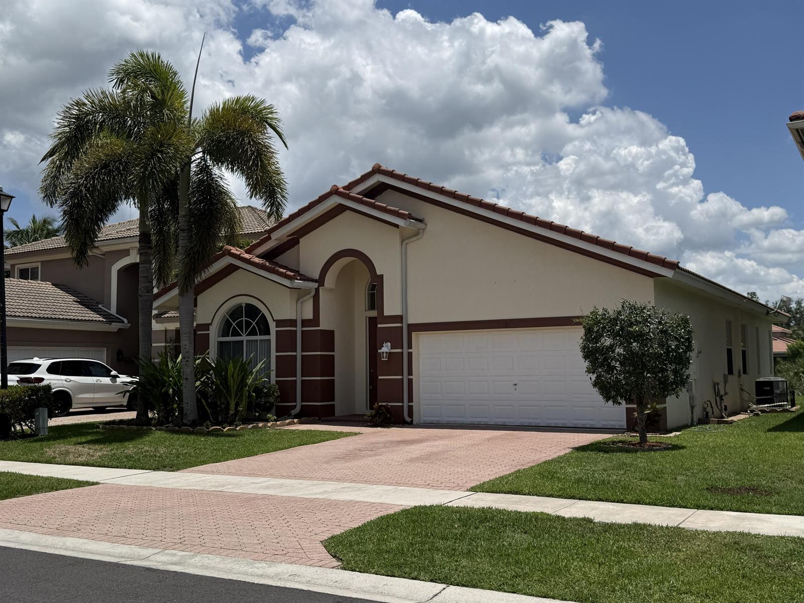 A single-story house with a white garage, beige stucco walls, and a tiled roof — 9084 Silver Glen Way, Lake Worth FL 33467, LAKE WORTH, FL
