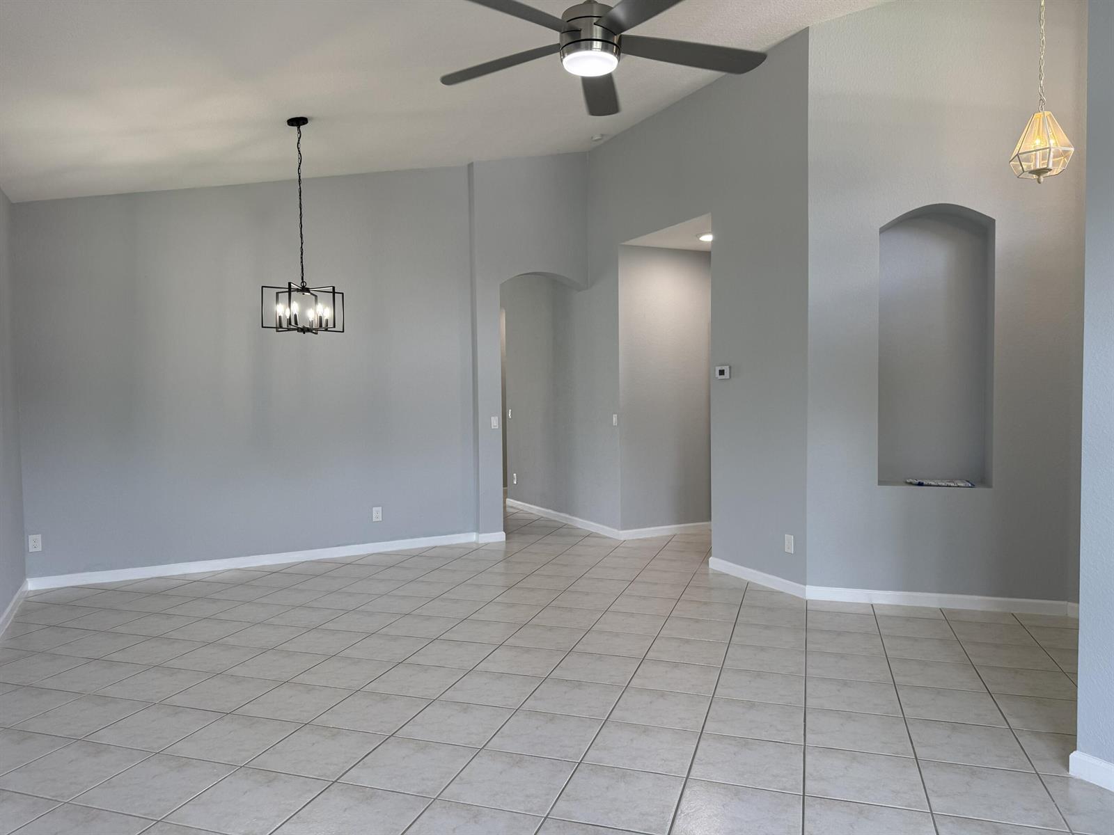 An empty room features gray walls, tile flooring, a ceiling fan, and two light fixtures — 9084 Silver Glen Way, Lake Worth FL 33467, LAKE WORTH, FL