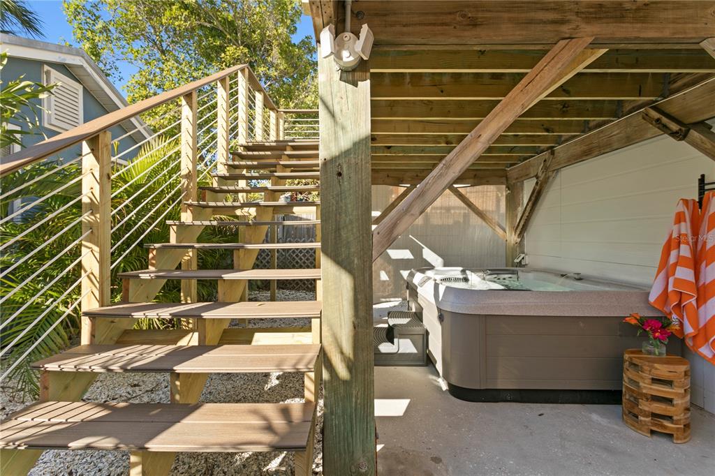 A hot tub sits under a wooden deck with stairs leading to an upper level — 800 GULF BOULEVARD UNIT 5, INDIAN ROCKS BEACH, FL