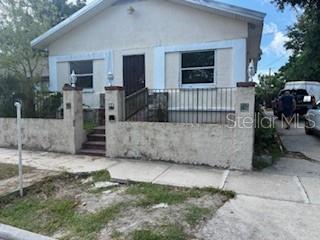 A single-story house with a stucco exterior, a front porch, and a low perimeter wall — 2405 E 17TH AVENUE, TAMPA, FL