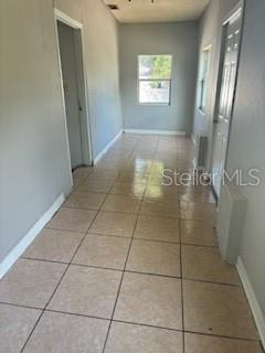 A hallway with light-colored tile flooring leads toward a window at the far end — 2405 E 17TH AVENUE, TAMPA, FL