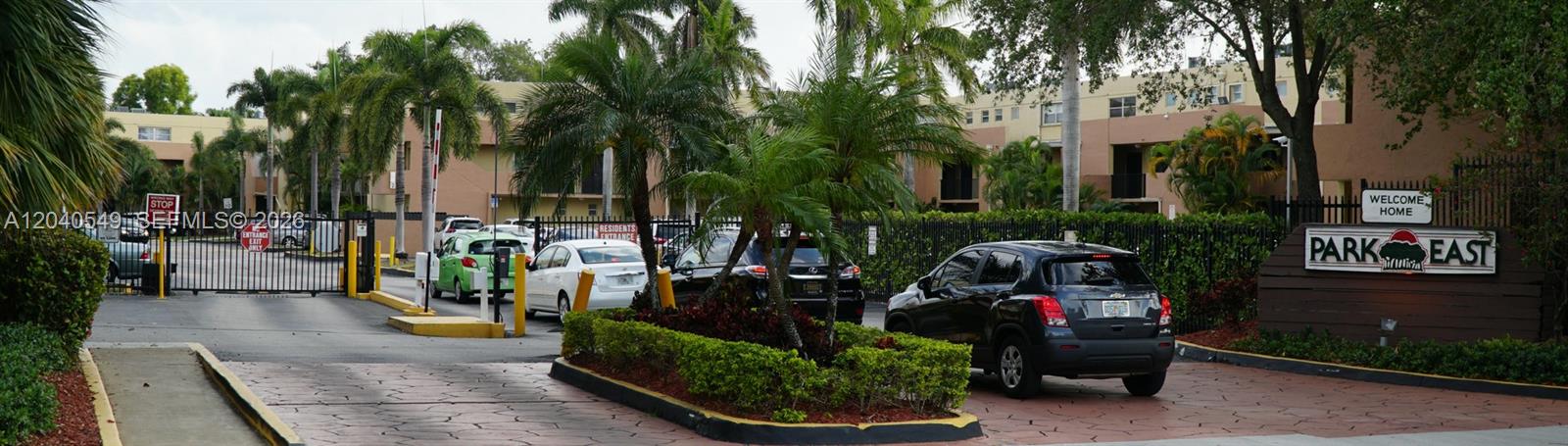 The entrance to the Park East residential complex features a gated driveway and palm trees — 140 NW 87th Ave # G214, Miami FL 33172, MIAMI, FL