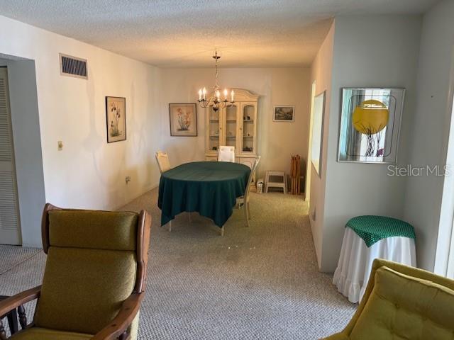 A dining area features a table with a green cloth, a hutch, and two chairs — 4700 COVE CIRCLE UNIT 203, ST PETERSBURG, FL