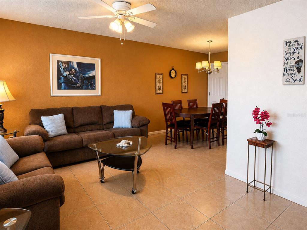 A living room with brown sofas and a dining area with a wooden table and chairs — 6044 22ND AVENUE N UNIT 2, ST PETERSBURG, FL