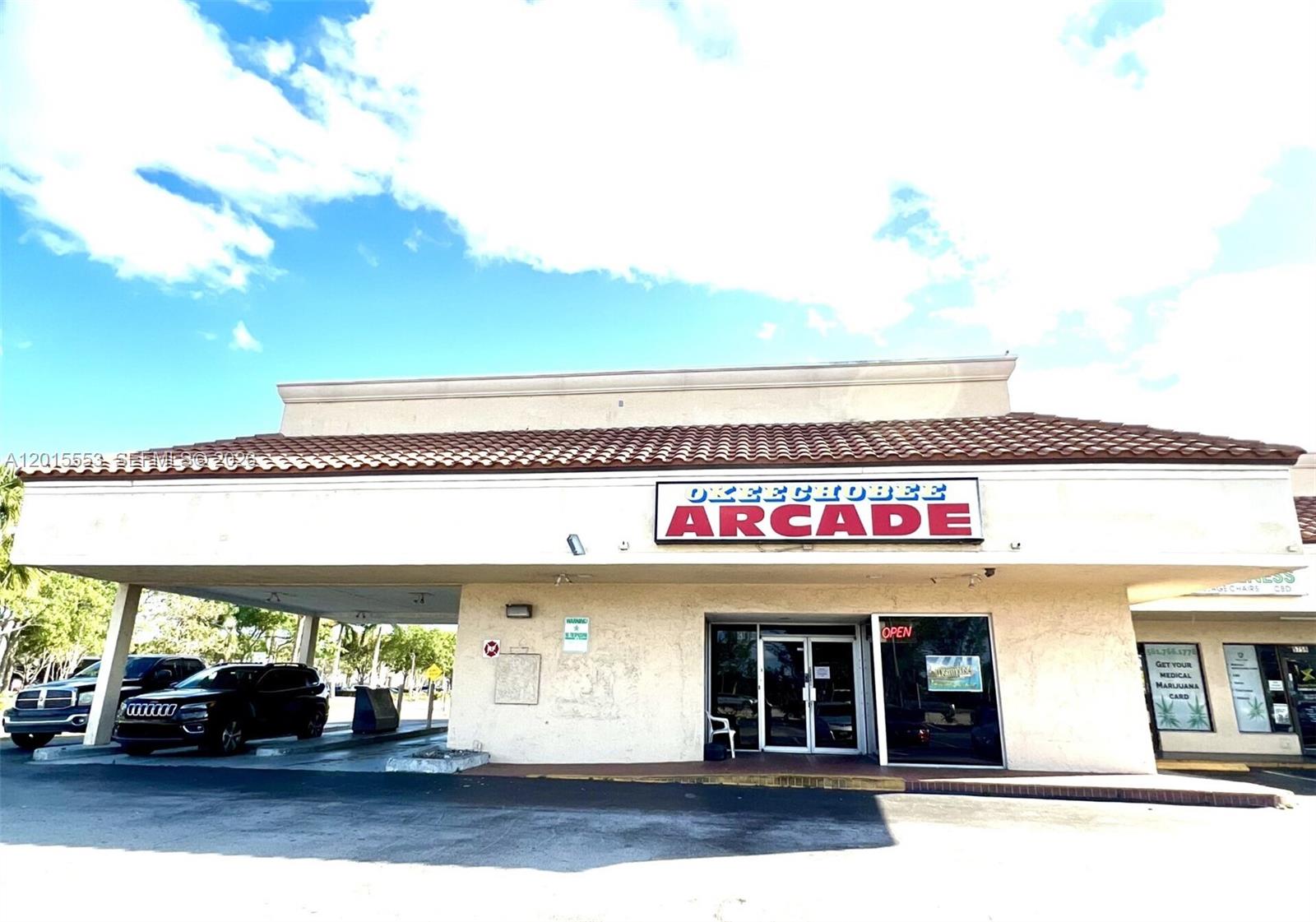 The exterior of a commercial building features a sign reading Okeechobee Arcade and a parking area — 5750 Okeechobee Blvd, FL 33417, FL