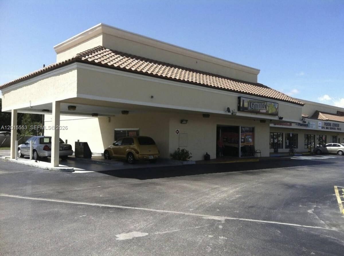 A commercial building exterior features a covered drive-thru lane and a parking lot — 5750 Okeechobee Blvd, FL 33417, FL