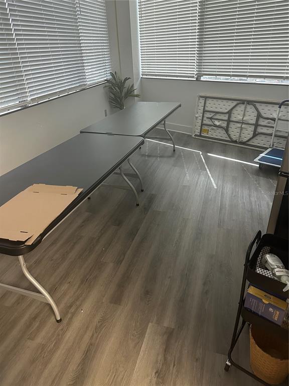 A room with grey wood-look flooring, two folding tables, and windows with horizontal blinds — 4106 W LAKE MARY BOULEVARD UNIT 205, LAKE MARY, FL