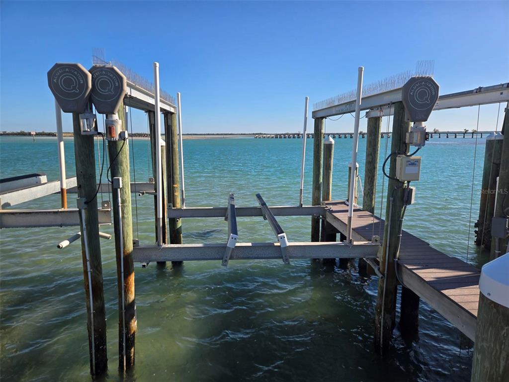 A boat lift with metal framing and wooden pilings sits over calm water — 6040 BOCA GRANDE CAUSEWAY UNIT 11 Boat Slip, BOCA GRANDE, FL