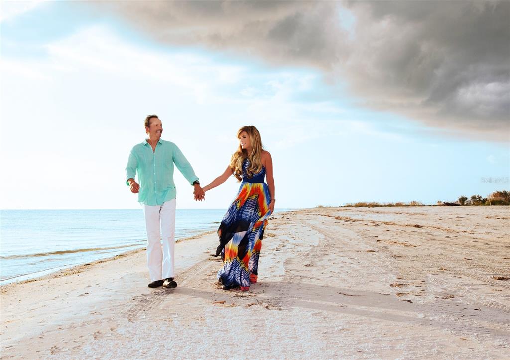 A man and a woman hold hands while walking along a sandy beach — 177 GULF BOULEVARD UNIT A, PLACIDA, FL