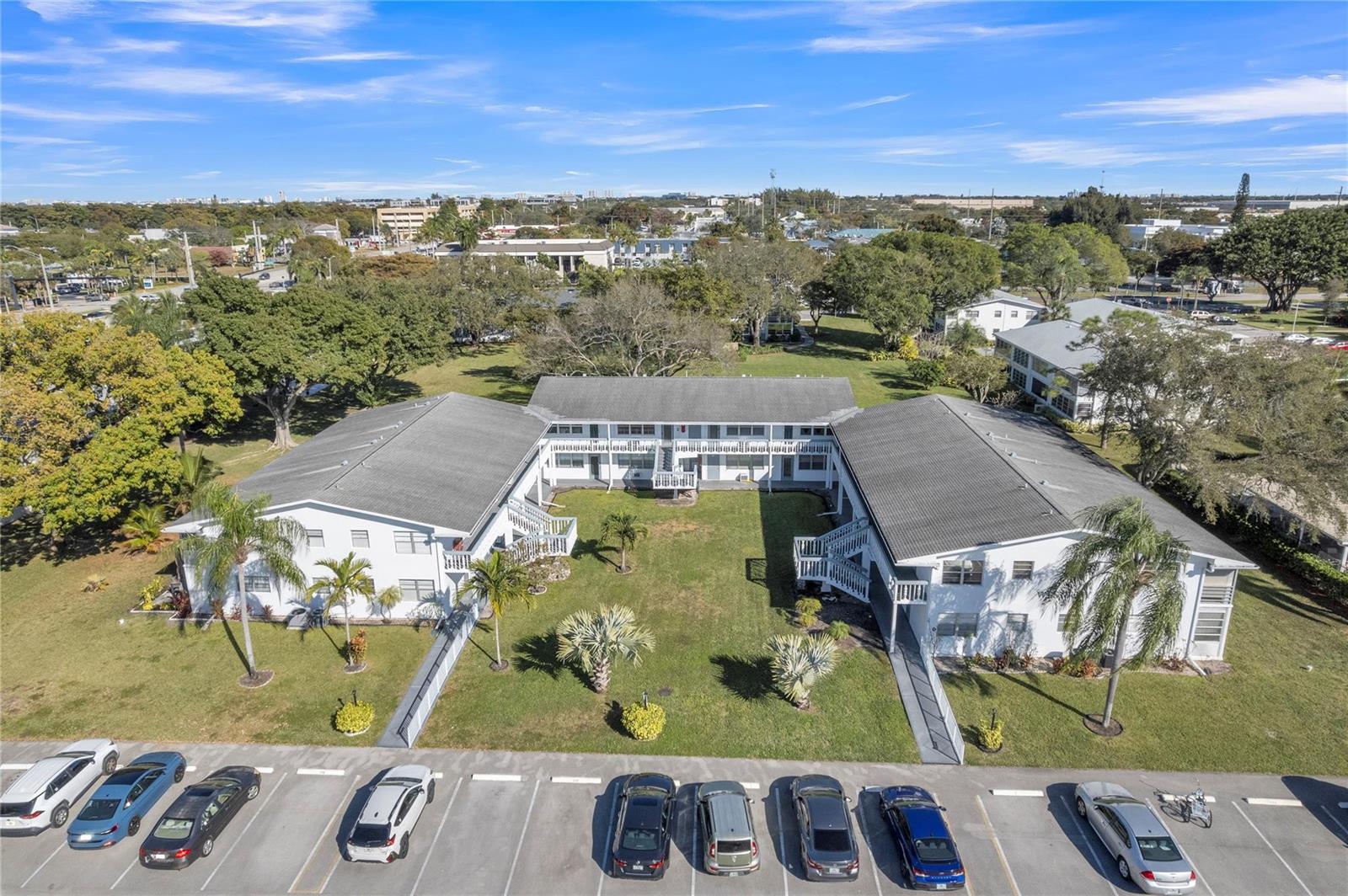 An aerial view of a two-story apartment complex with a central courtyard and parking lot — 176 Westbury J # 176, Deerfield Beach FL 33442, DEERFIELD BEACH, FL