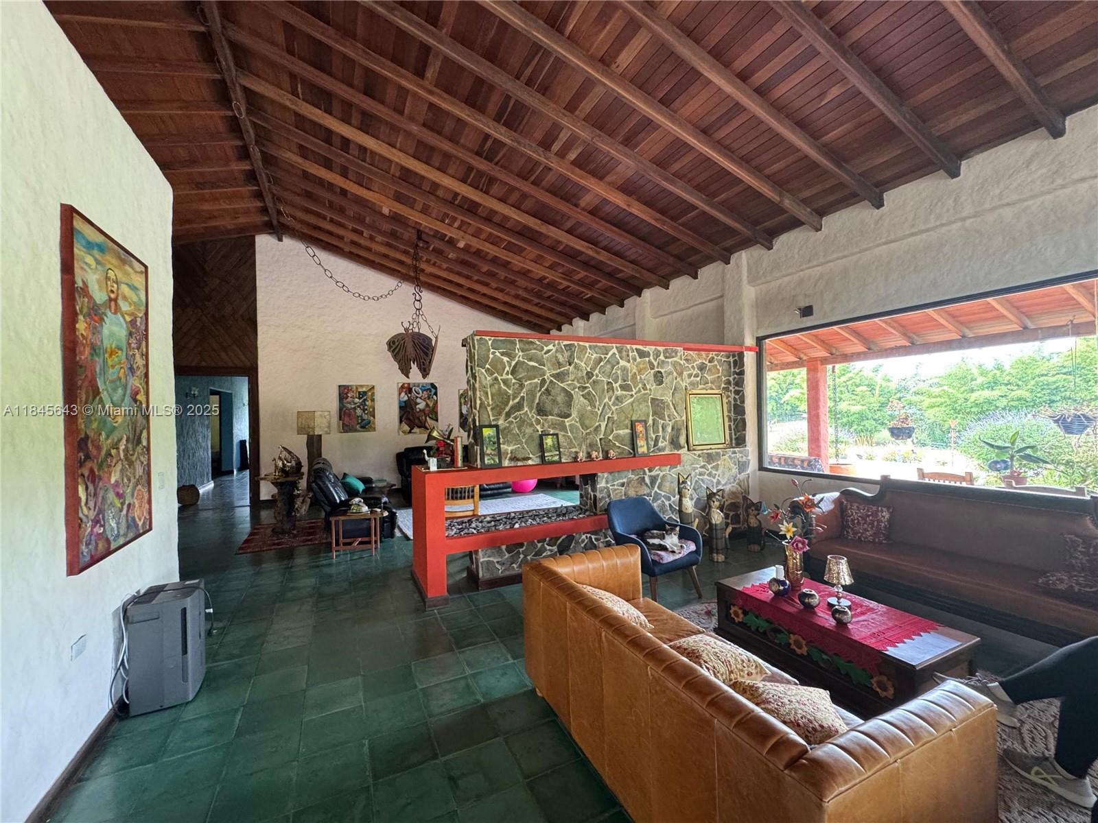 A living room features a vaulted wood ceiling, stone accent wall, and green tile floors — 2222 via Filandia/Armenia, NA, NA