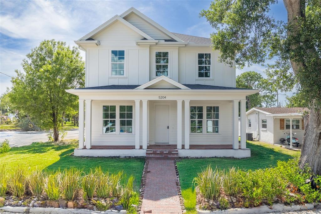 A two-story white house with a front porch, columns, and a brick walkway — 5204 10TH STREET N, ST PETERSBURG, FL