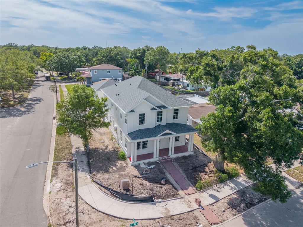 A covered patio features brick pavers, white horizontal siding, and a glass-paneled door — 5204 10TH STREET N, ST PETERSBURG, FL