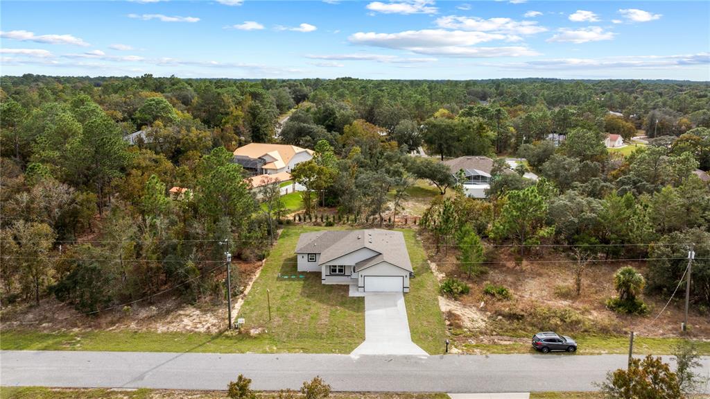 An aerial view shows a single-story house with a garage and driveway on a wooded lot — 3416 W EUNICE DRIVE, DUNNELLON, FL