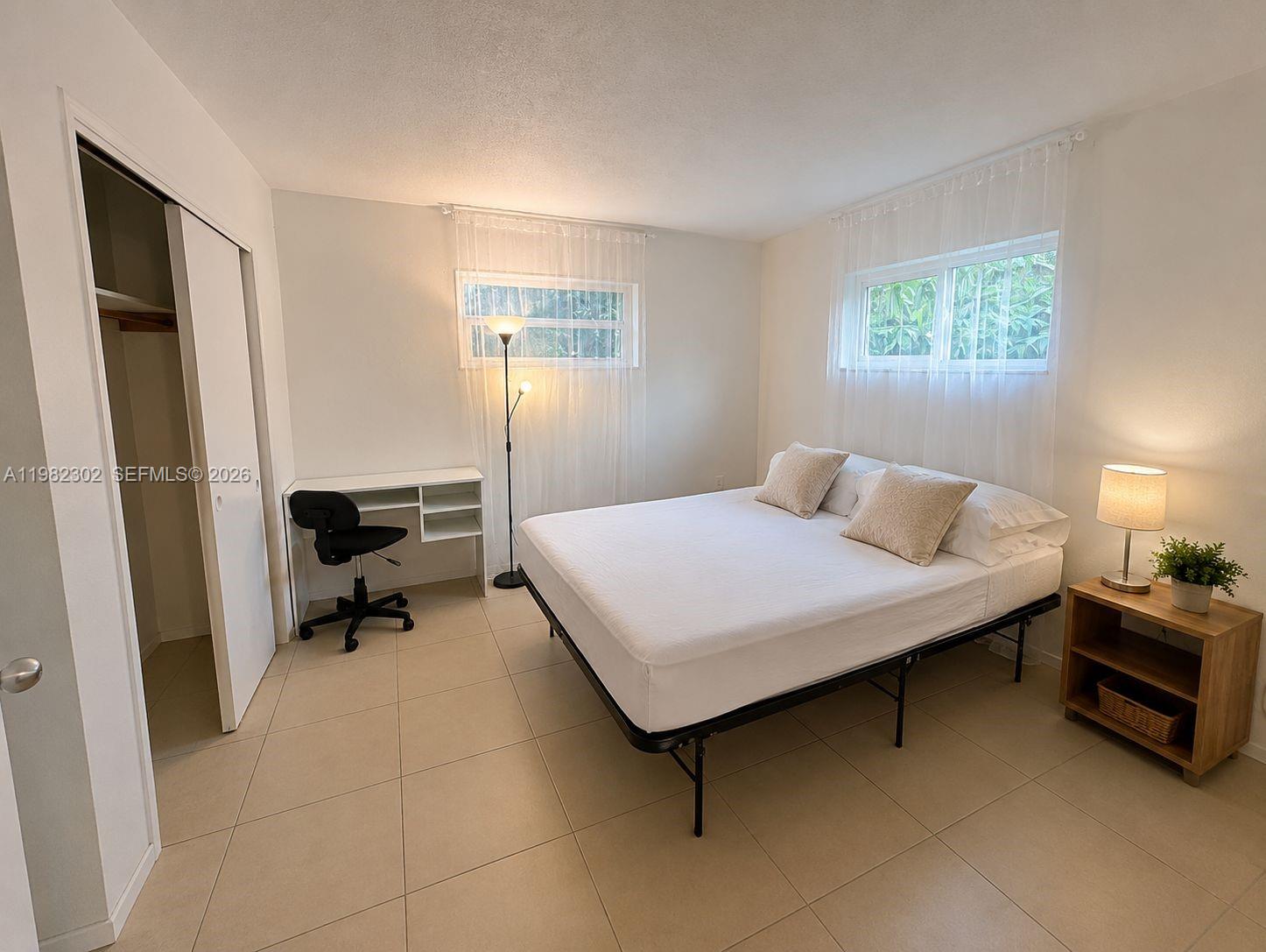 A bedroom features a bed, a desk, a closet, and tile flooring — 2620 SW 51st St # 2, Dania Beach FL 33312, DANIA BEACH, FL