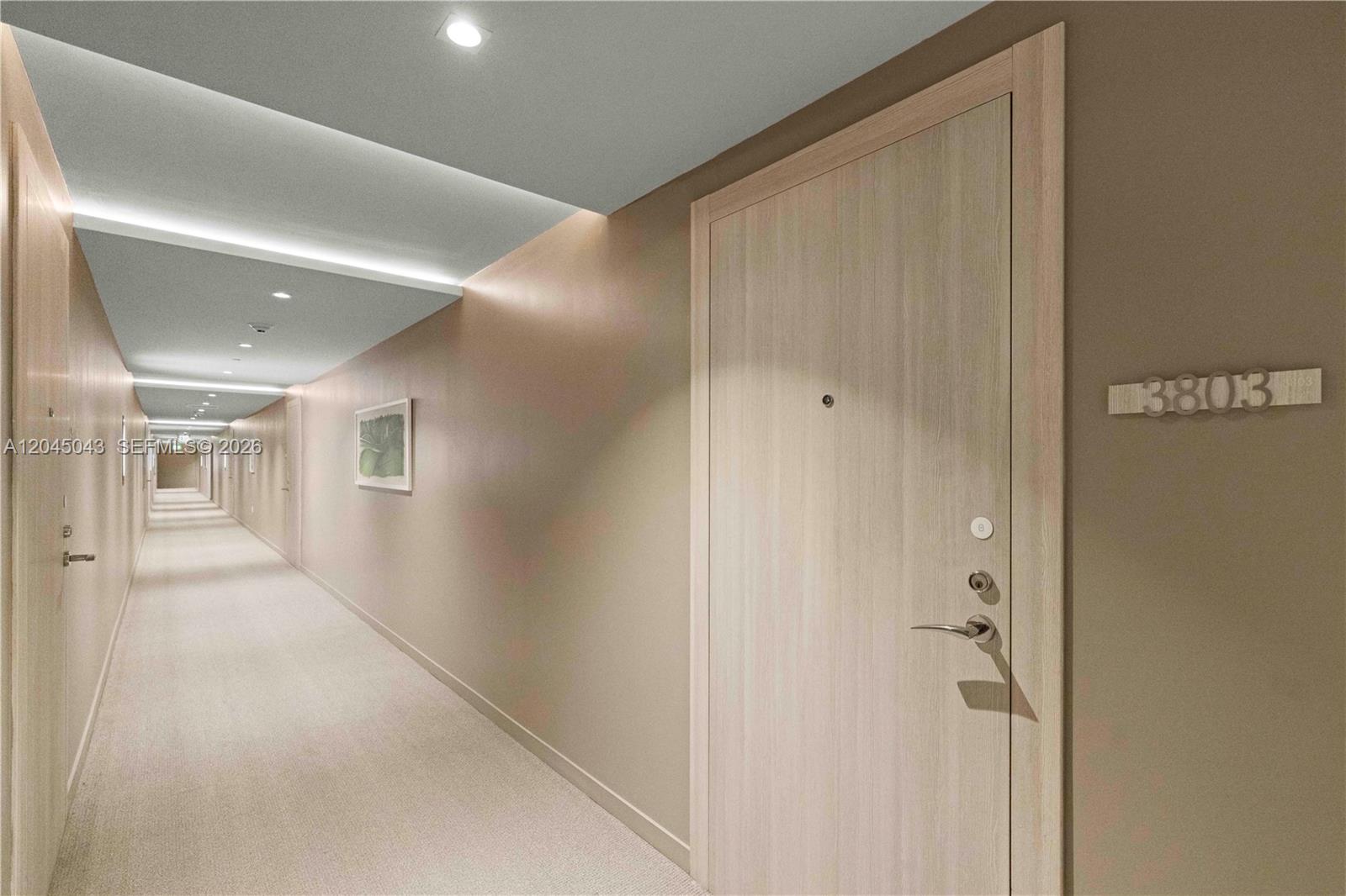 A long, carpeted hallway features light wood doors and recessed ceiling lighting — 1000 E Brickell Plz # 3803, Miami FL 33131, MIAMI, FL
