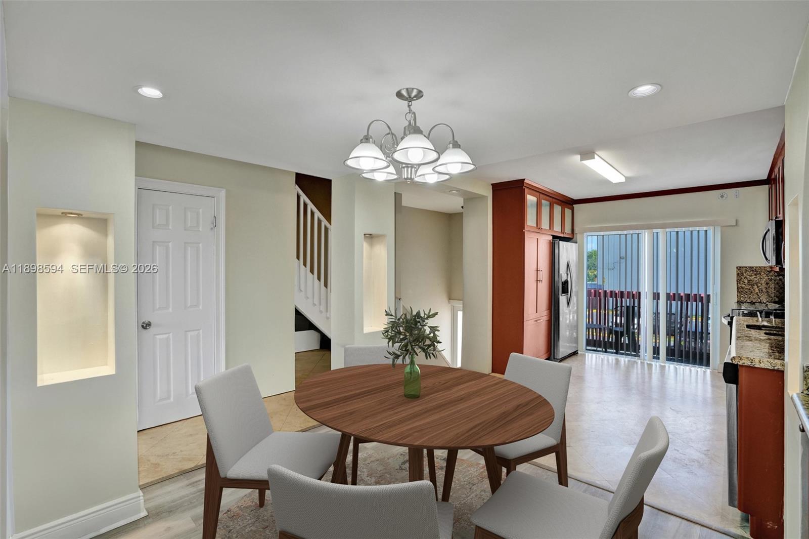 A dining area features a round wooden table, four chairs, and a nearby kitchen — 4350 W 11th Ct # 62, Hialeah FL 33012, HIALEAH, FL