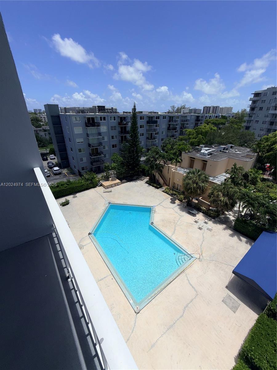 An elevated view of a swimming pool surrounded by a patio and apartment buildings — 1470 NE 125th Ter # 605, North Miami FL 33161, NORTH MIAMI, FL