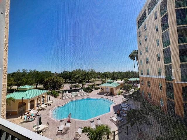 A high-angle view of a swimming pool area surrounded by a building and palm trees — 2060 MATECUMBE KEY ROAD UNIT 2301, PUNTA GORDA, FL
