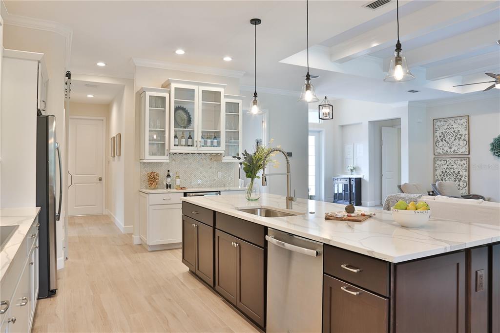 A kitchen features a large marble-topped island, dark cabinetry, and white upper cabinets — 7808 34TH COURT E, SARASOTA, FL
