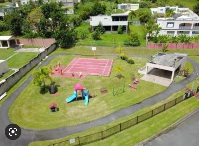 An aerial view of a neighborhood park featuring a playground, basketball court, and covered pavilion — Estancias del Verde CALLE 3 UNIT #71, RIO GRANDE, PR