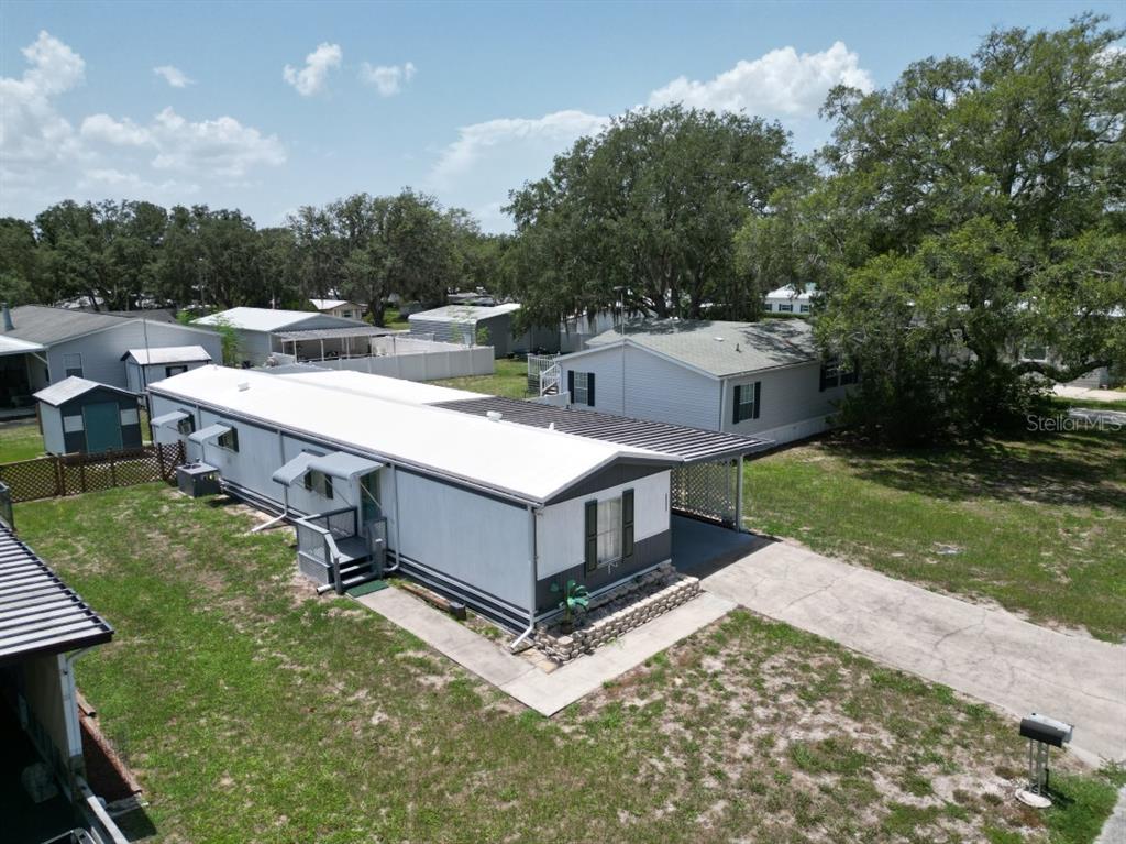 An aerial view of a mobile home with a metal carport and a concrete driveway — 34940 FRASER STREET, DADE CITY, FL