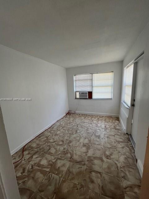 An empty room with white walls, a window air conditioning unit, and patterned tile flooring — 901 SW 4th Ter, Hallandale Beach FL 33009, HALLANDALE BEACH, FL