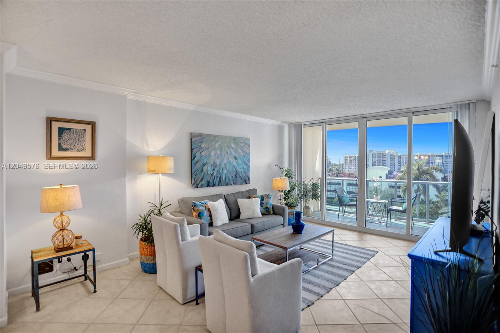 A living room features a gray sofa, two white armchairs, and a balcony with views — 2501 S Ocean Dr, Hollywood FL 33019, HOLLYWOOD, FL
