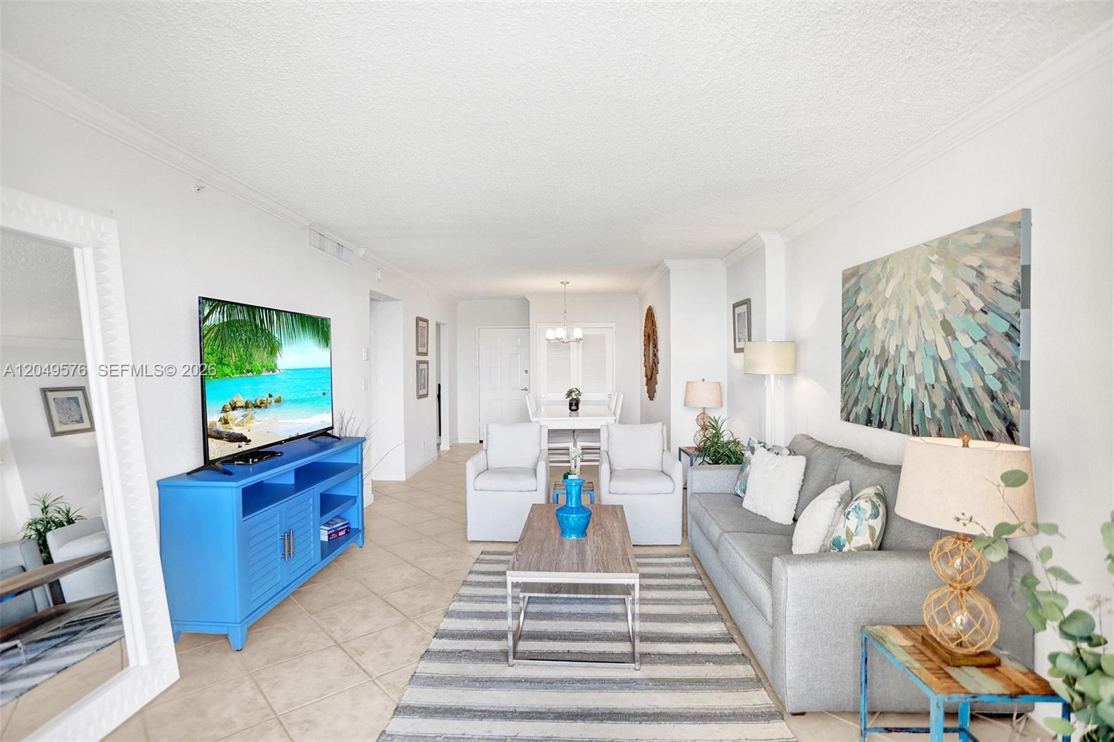 A living room features a blue media console, gray sofa, and a striped area rug — 2501 S Ocean Dr, Hollywood FL 33019, HOLLYWOOD, FL