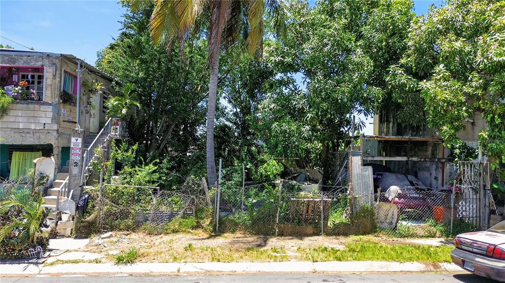 An exterior view shows a residential lot with a house, overgrown vegetation, and a car — 11 ST. EXT. JARDINES DE PALMAREJO, V-20, CANOVANAS, PR