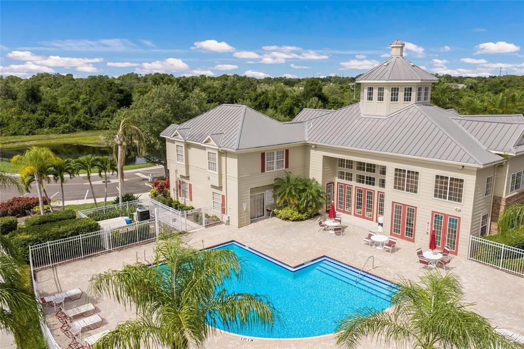 An aerial view of a community clubhouse with a swimming pool and surrounding landscaping — 7633 PLANTATION CIRCLE UNIT 7633, UNIVERSITY PARK, FL