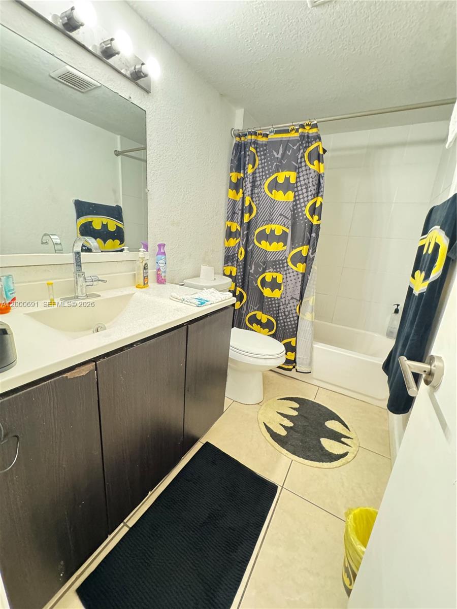 A bathroom features a dark vanity, a Batman-themed shower curtain, and a matching floor mat — 15201 NE 6th Ave # C304, Miami FL 33162, MIAMI, FL