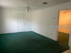 A room with white walls, a ceiling fan, and green carpeting — 804 WASHINGTON PALM LOOP UNIT 5, DAVENPORT, FL