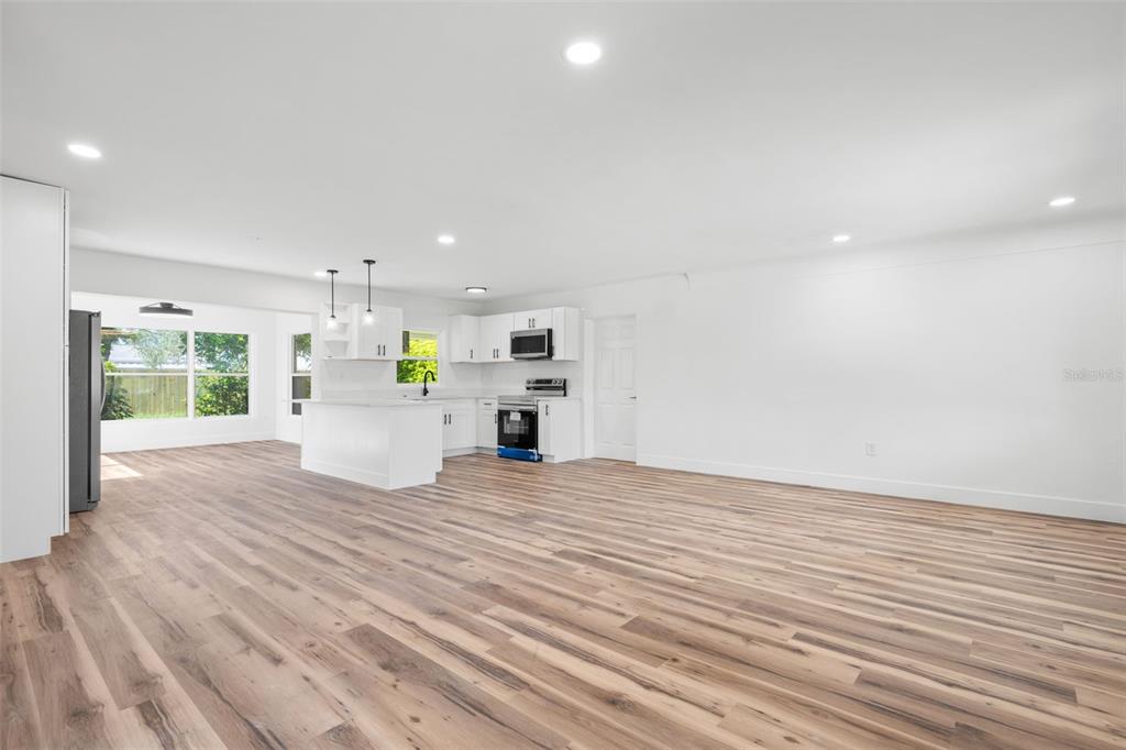 A walk-in shower features white marble-look wall tiles, a built-in niche, and a showerhead — 6116 52ND AVENUE N, KENNETH CITY, FL