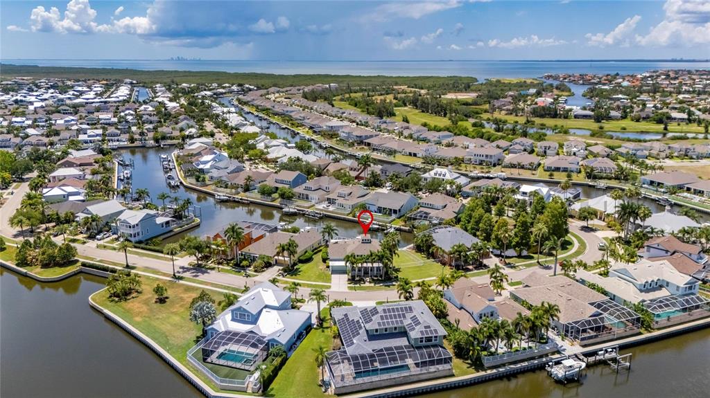 An aerial view shows a waterfront residential neighborhood with a red circle highlighting a house — 508 ISLEBAY DRIVE, APOLLO BEACH, FL