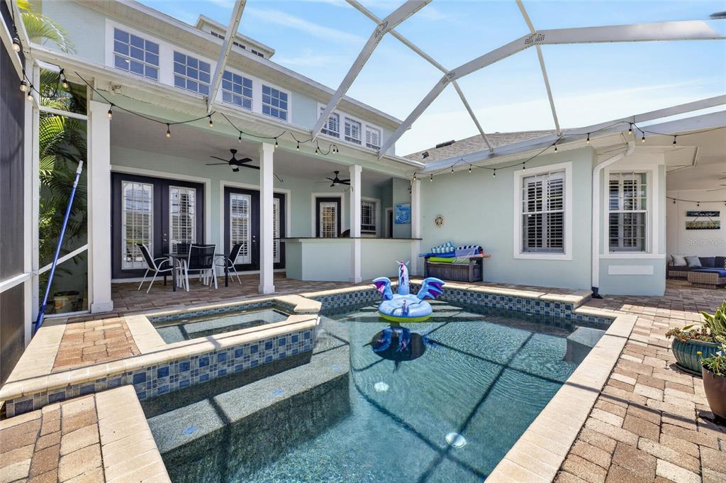 A screened-in patio features a swimming pool, a hot tub, and an outdoor bar area — 508 ISLEBAY DRIVE, APOLLO BEACH, FL