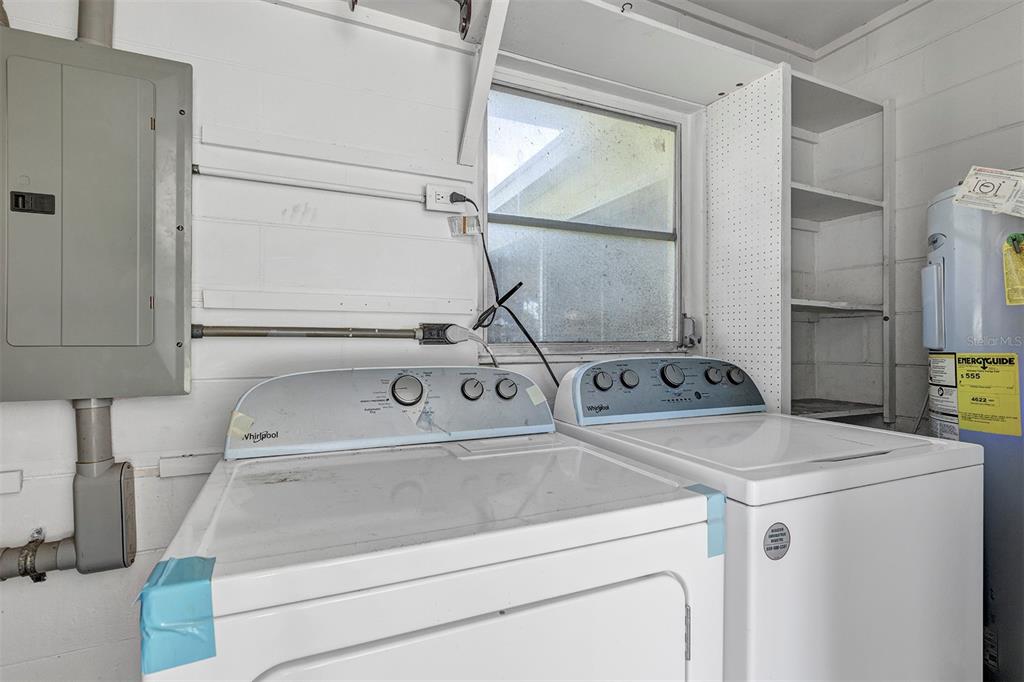 A laundry room features a white washer and dryer, a water heater, and an electrical panel — 9375 SE 163RD LANE, SUMMERFIELD, FL