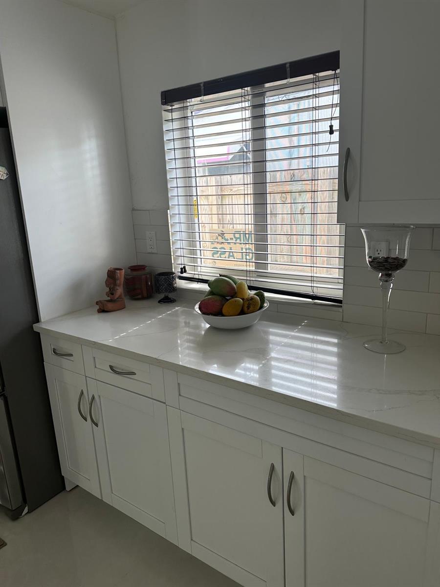 A kitchen counter with white cabinets, a quartz countertop, and a window with blinds — 2645 Scott Street, Hollywood FL 33020, HOLLYWOOD, FL