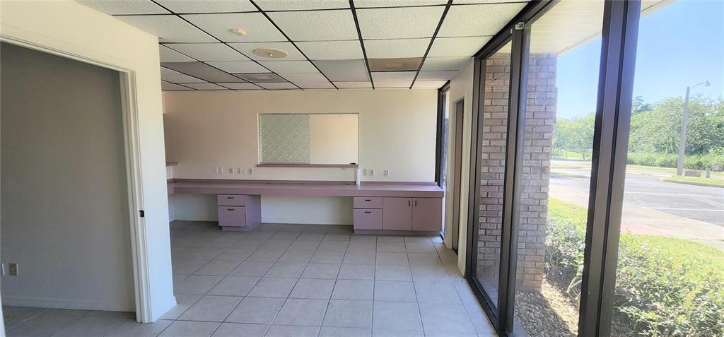 An office space features a long pink counter, tile flooring, and large floor-to-ceiling windows — 150 SE 17TH STREET UNIT 603, OCALA, FL
