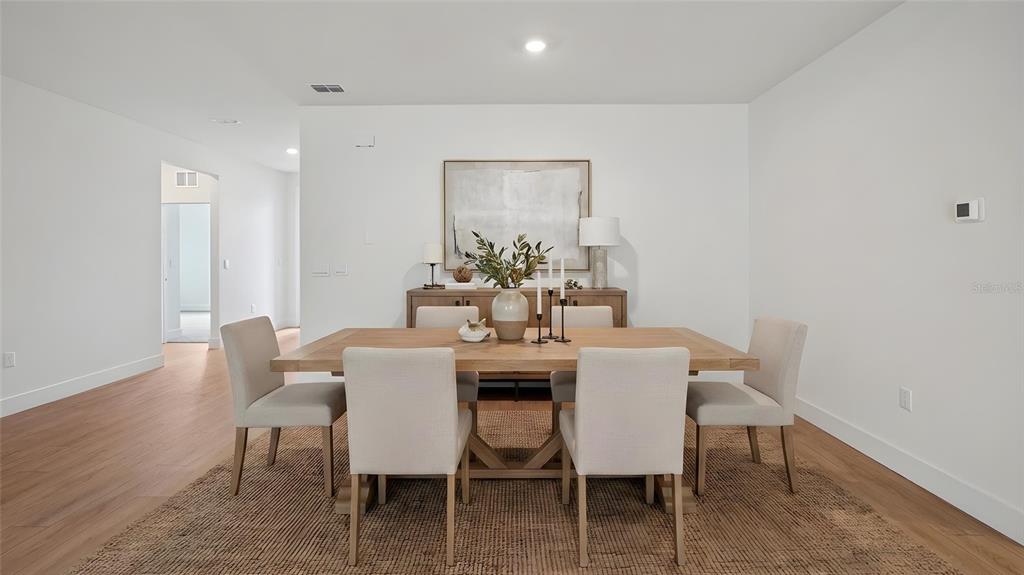 A dining room features a wooden table, six upholstered chairs, and a sideboard against a wall — 17100 NW 180TH TERRACE, ALACHUA, FL