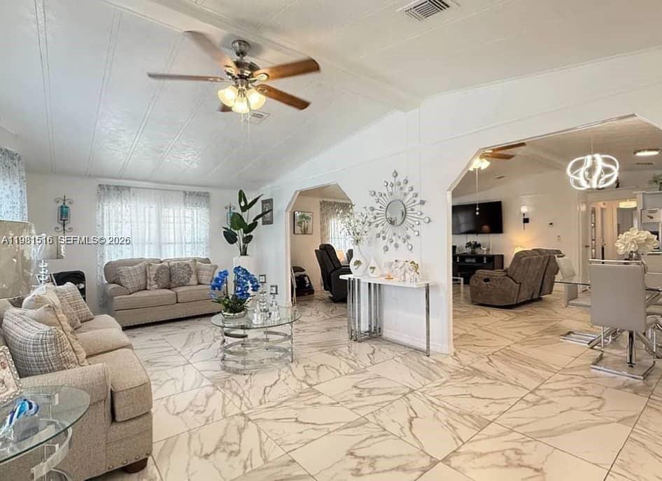 A bright living room features white marble-look tile floors, neutral furniture, and arched wall openings — 215 LAURELCREST CIR VALRICO, Brandon FL 33594, BRANDON, FL