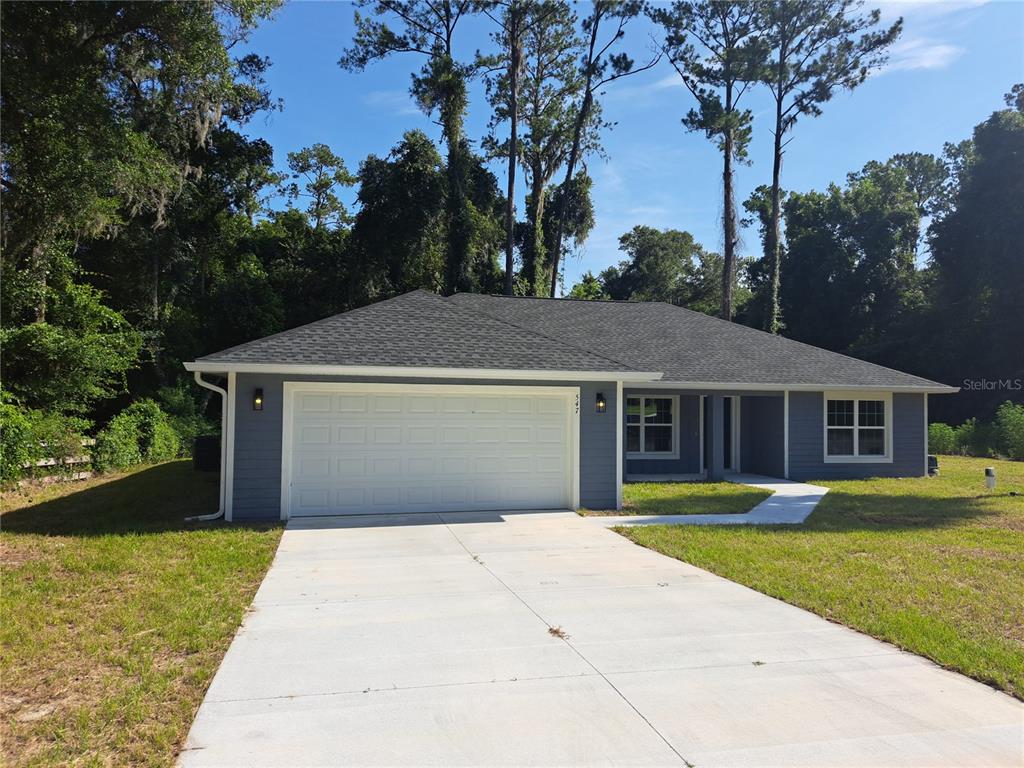 A single-story house with blue siding, a two-car garage, and a concrete driveway — 547 GRAPEWOOD LN., CITRUS SPRINGS, FL